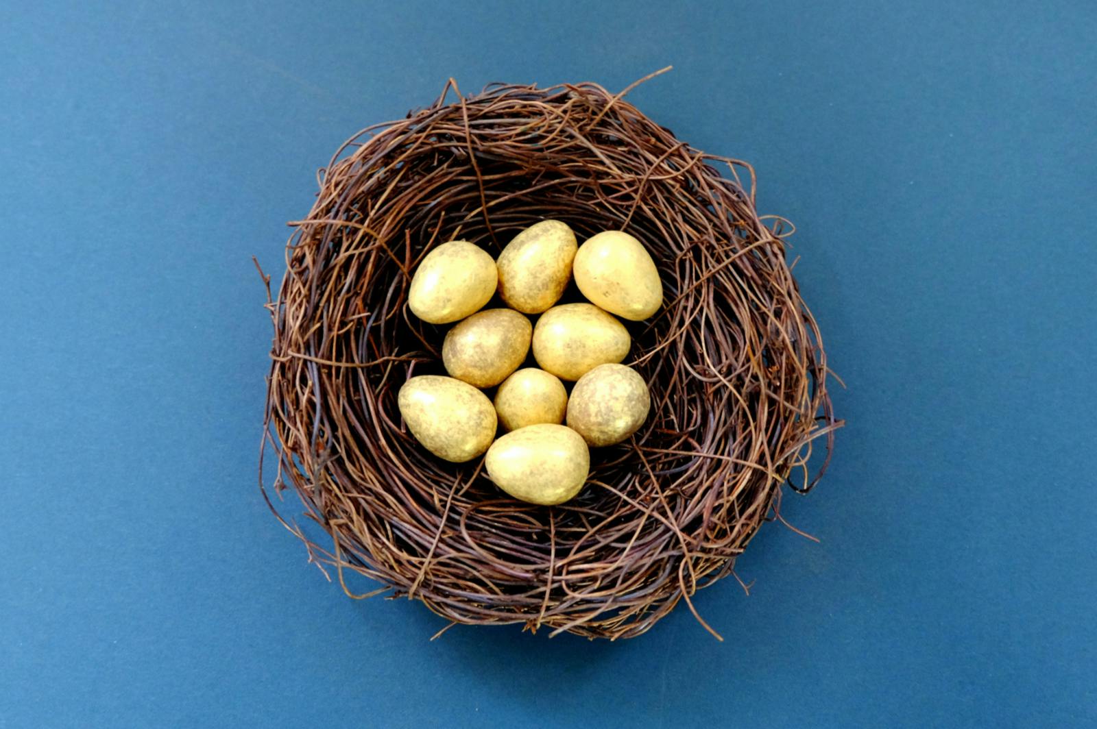 A wicker basket holding nine golden eggs on blue background representing a lack of or false diversification in online ad strategy, which b00st.com helps to solve for artists across the music industry.